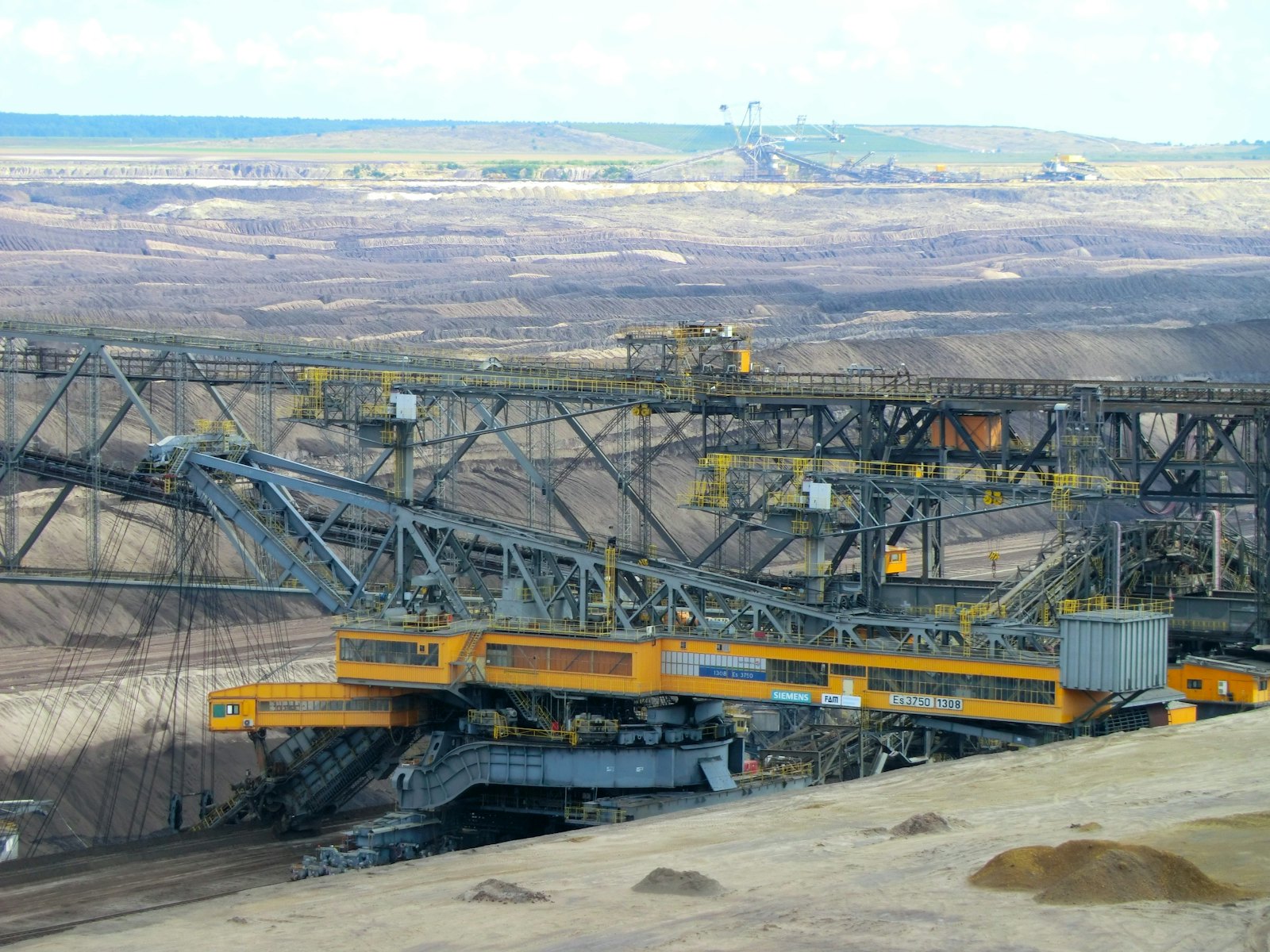 Excavator digging on an open red dirt site