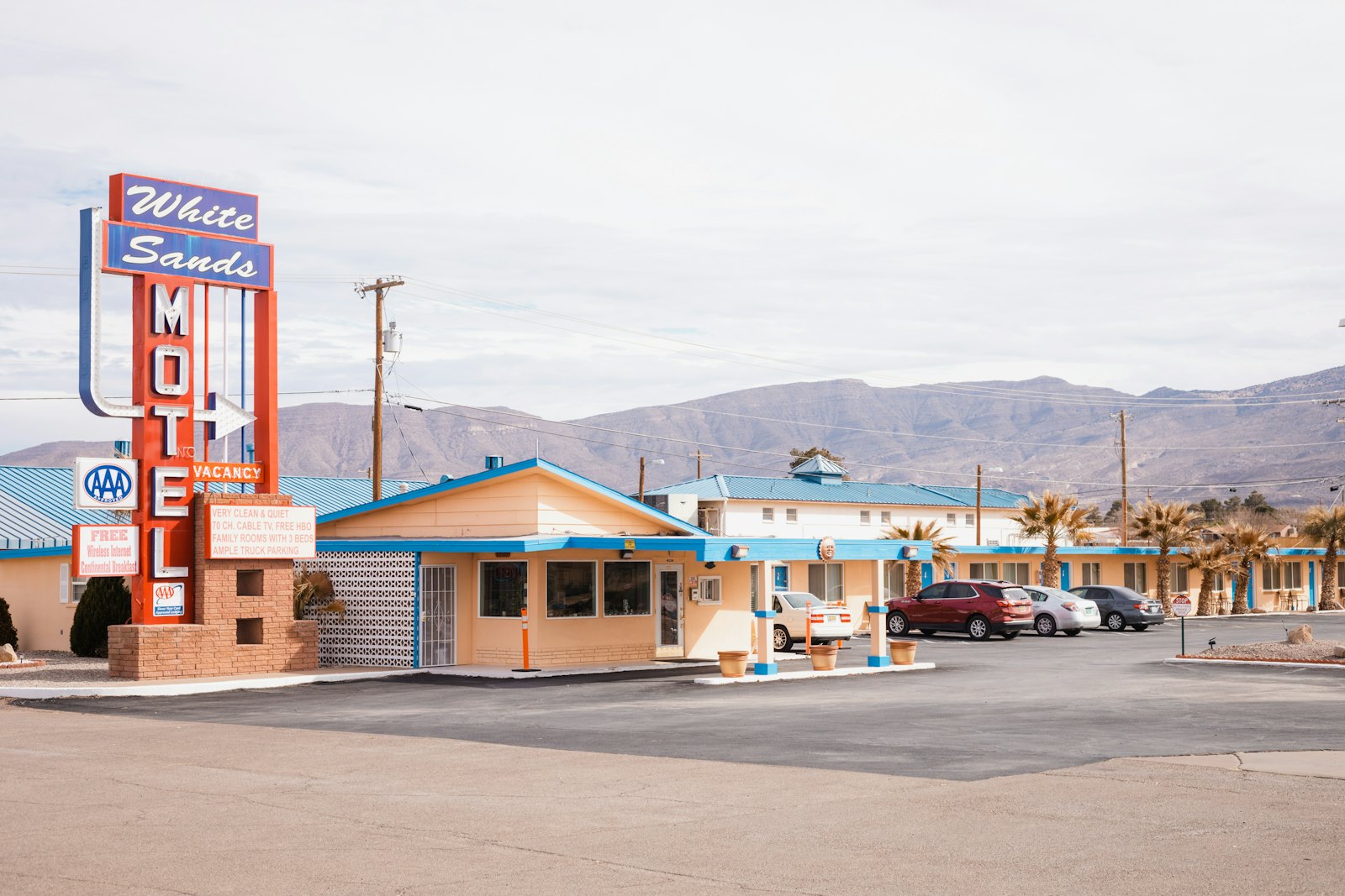 Cars parked outside a roadside motel at dusk