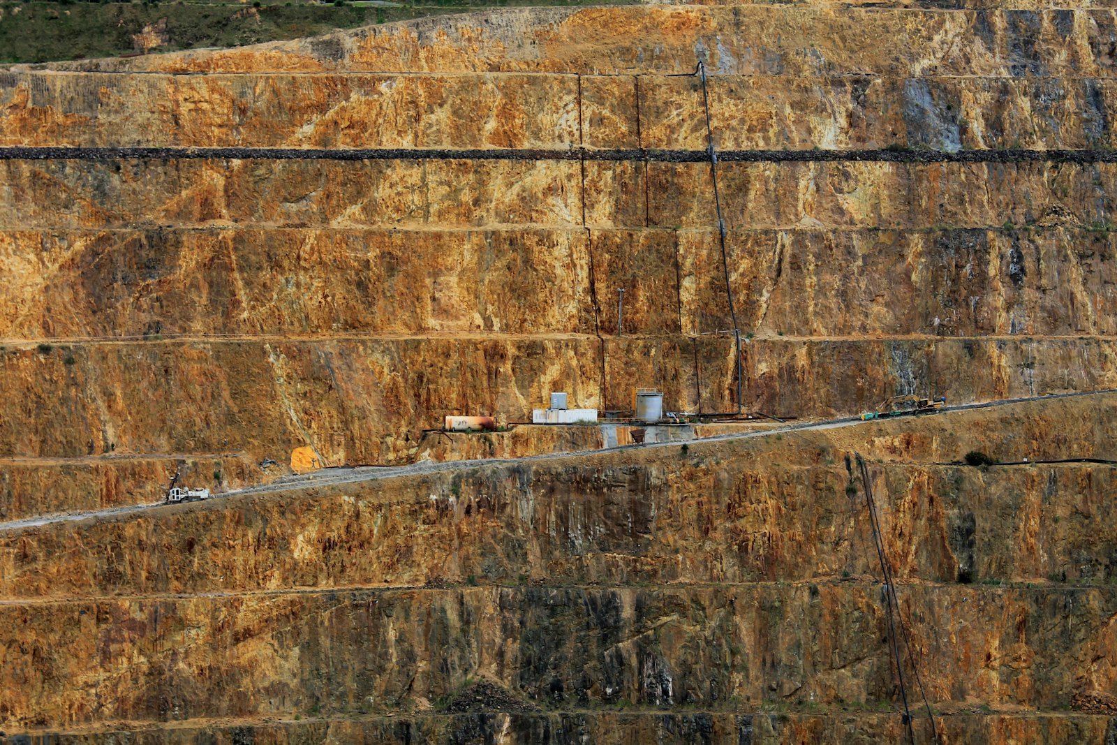 A haul road cut through the walls of a huge open pit