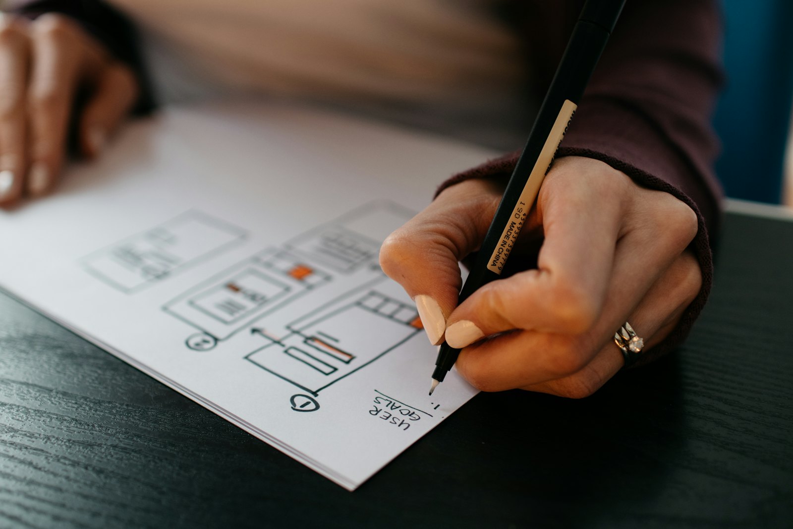 Person sketching a website layout on paper